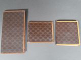 three pieces of brown and brown leather on a gray surface