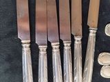 several knives and a penny are sitting on a black cloth
