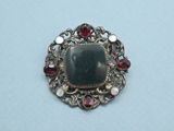 a close up of a broochle with a stone in it