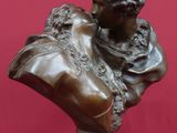 un buste antique en bronze représentant une femme, posé sur un socle