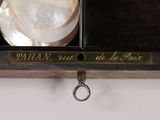 a plate and a cup on a shelf with a name plate