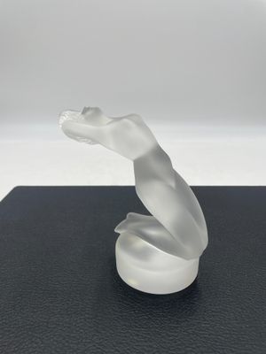 une image représentant une sculpture blanche en forme de serpent posée sur une surface noire
