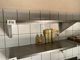 a metal shelf with bottles of condiments on it in a kitchen