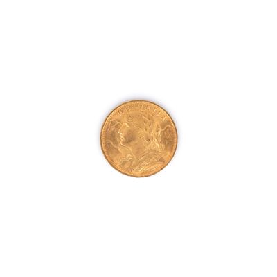 gros plan d'une pièce d'or sur une surface blanche