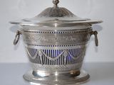 a silver bowl with a lid on a table
