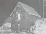 a black and white photo of a barn in the snow