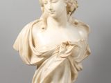 a white marble bust of a woman on a clear base