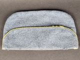 un gros plan sur un sac gris muni d'une fermeture éclair jaune