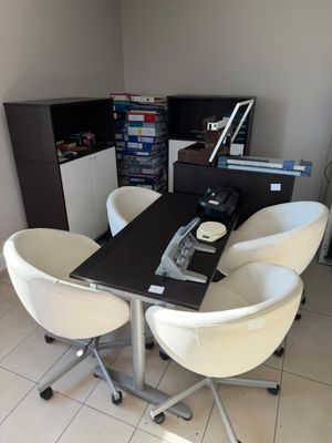a black table with four white chairs around it
