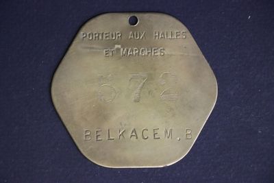 an old brass medal with the name of a man on it
