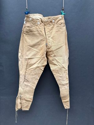 un vieux pantalon suspendu à une corde à linge accrochée au mur