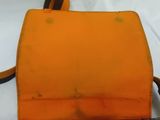 an orange purse sitting on top of a white table