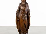 a wooden statue of a man with a robe and a hat