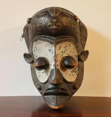 un masque noir et blanc posé sur une table en bois
