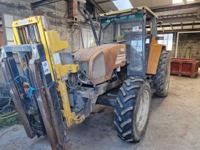un tracteur jaune garé dans un garage