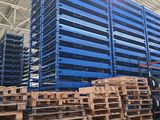pallets stacked up in a warehouse with lots of blue pallets