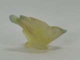 a yellow bird that is sitting on a white surface
