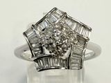 une photo d'une bague en diamant et en or blanc posée sur une surface claire