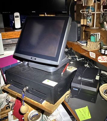 un ordinateur posé sur un bureau dans une pièce encombrée