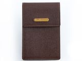 un porte-cartes marron orné d'une barre dorée sur le devant