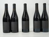 four bottles of wine are lined up on a white surface