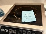 une cuisinière noire et argentée avec un mot posé sur le brûleur