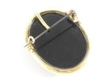 an image of a gold and black broochle with a pin