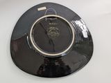 a black plate with a gold rim on a white table