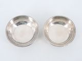 pair of silver plated bowls on a white surface