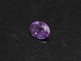 un gros plan d'une pierre précieuse violette sur une surface noire