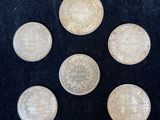 six silver coins are arranged in a circle on a black surface