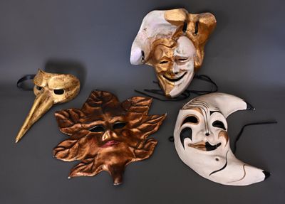 trois masques sont posés sur une table, et une main en tient un