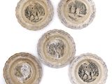 four plates with images of people on them on a white surface