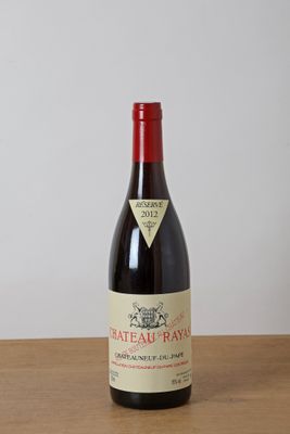 une bouteille de vin rouge posée sur une table en bois