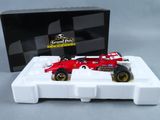 La voiture de course rouge est posée sur un plateau blanc.