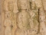 a stone carving of a buddha surrounded by other statues