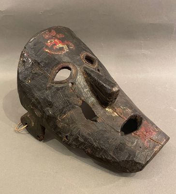 un masque en bois percé d'un trou au milieu