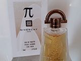 Un flacon de parfum Givenchy et son coffret posés sur un comptoir, avec une boîte de parfum en arrière-plan