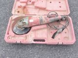 une mallette rose posée par terre, contenant des outils