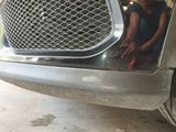 a little girl that is sitting in front of a car