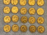 a pile of old gold coins on a gray surface