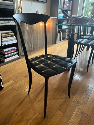 a black chair in the middle of a wooden floor