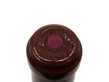 a close up of a bottle of wine on a white surface