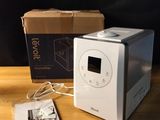 a white toaster sitting on a wooden table next to a box
