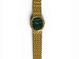 an image of a gold watch with a green face on a chain