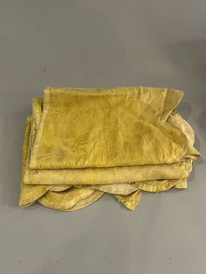 trois morceaux de tissu posés sur une table, à côté d'une tasse
