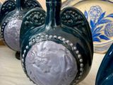 Plusieurs vases bleus sont alignés sur une table recouverte d'une nappe blanche.