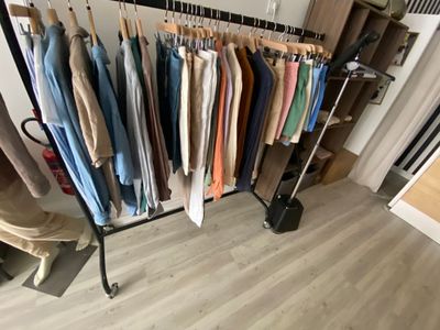 a rack of clothes hanging on a clothes rack in a room