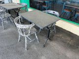 tables and chairs outside of a restaurant with a large painting on the wall