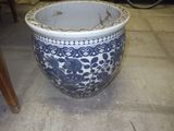 un grand vase bleu et blanc posé par terre